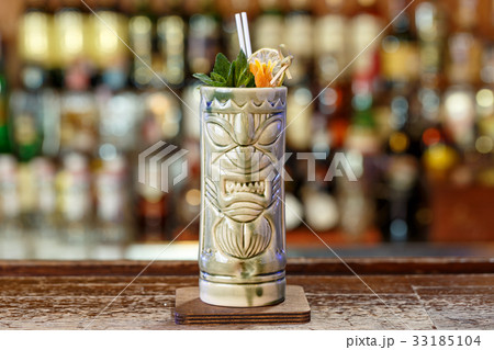 Exotic cocktail in a tiki glass Exotic cocktail in a tiki glass 33185104