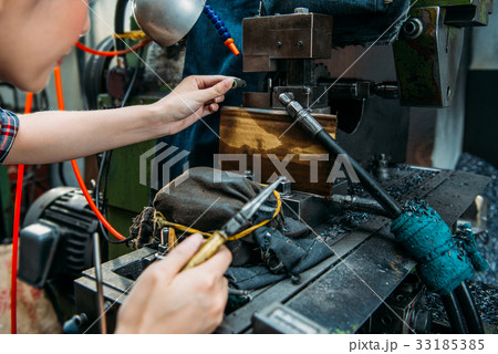 factory staff place parts in milling machine 33185385