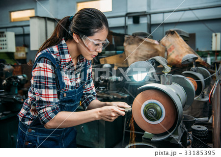 female worker holding components metal grinding 33185395