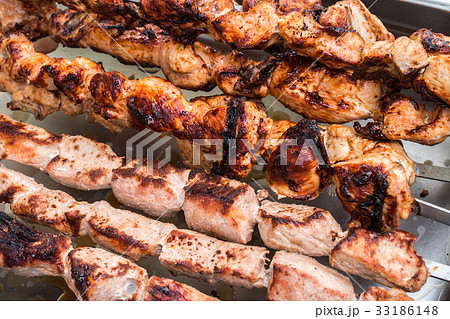 Shashlik roasting on hot grill, one piece scorched Shashlik roasting on hot grill, one piece scorched 33186148