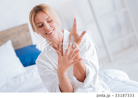 Happy emotional female looking downwards at her 33187333