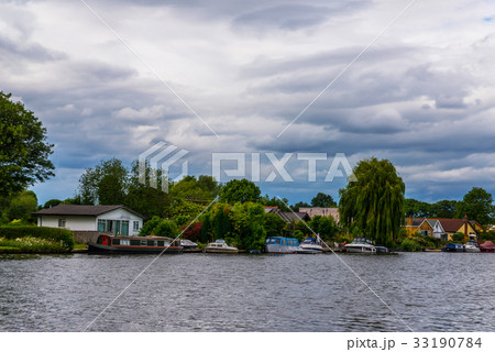 Wide river and houses on the shore, moored boats 33190784