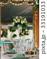 Mirror reflects vase with white roses 33191033