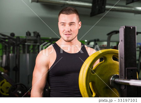 Young healthy man with big muscles holding disk Young healthy man with big muscles holding disk 33197101