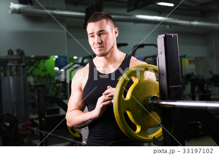 Young healthy man with big muscles holding disk 33197102