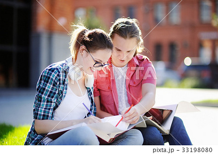 Young happy students with books and notes outdoors 33198080