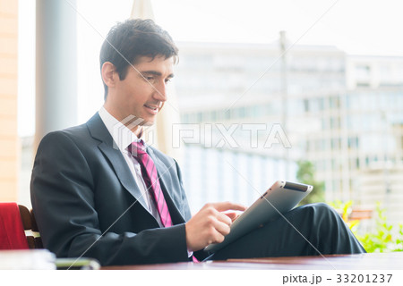 Young man wearing business suit while using a 33201237