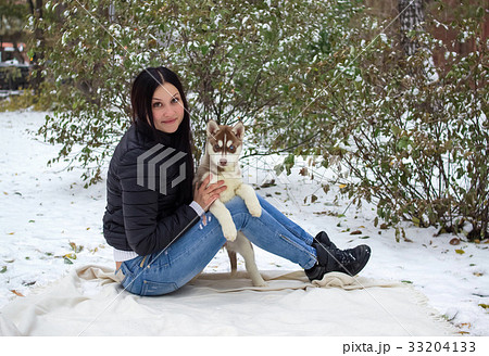 portrait of a young women with a husky puppies 33204133
