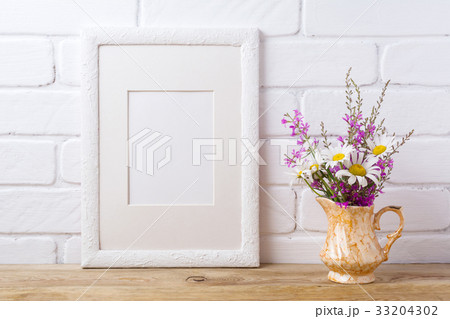 White frame mockup with chamomile, purple flowers 33204302