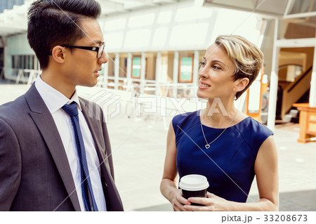 Two colleagues walking together in a city 33208673
