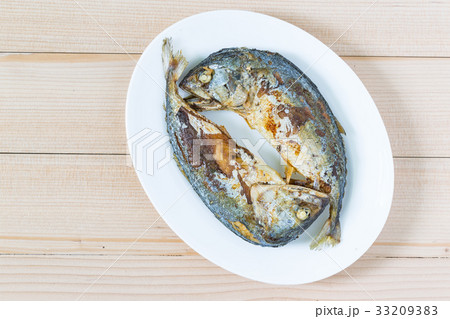 Fried two short mackerel fishes on wooden floor 33209383