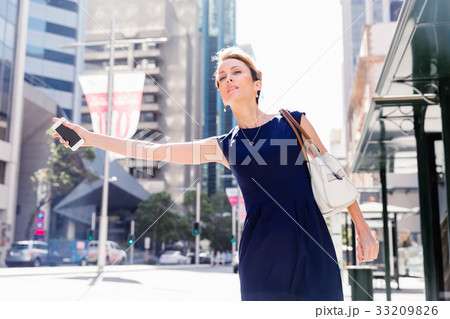 Waving for a taxi in city 33209826