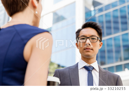 Two colleagues walking together in a city 33210255