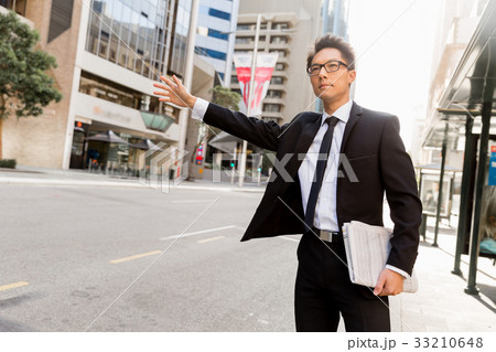 Waving for a taxi in city 33210648