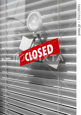 Closed sign board hanging outside store 33213691