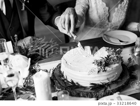 Bride and groom cutting wedding cake together 33218640