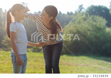 Loving mother gently touching her daughters Loving mother gently touching her daughters 33219839