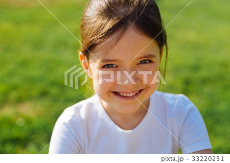 Portrait of smiling little girl against grassy Portrait of smiling little girl against grassy 33220231