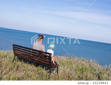 Father with child looking to the sea in front of Father with child looking to the sea in front of 33229641