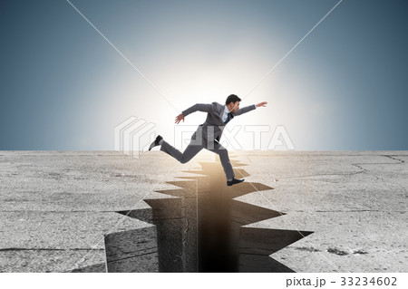 Businessman jumping over the cliff 33234602