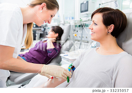 Nurse in drop-in department taking blood from 33235057