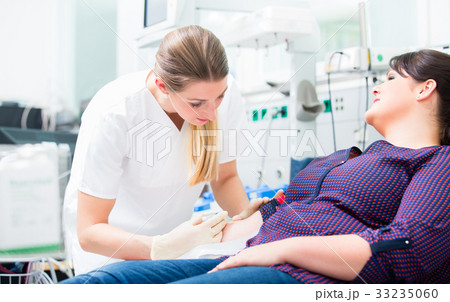 Nurse applying access at upper arm of patient 33235060