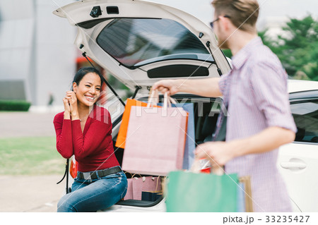 White man give shopping bags to happy Asian woman White man give shopping bags to happy Asian woman 33235427