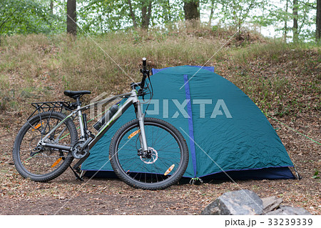 Mountain bike in front of closed tent in the woods 33239339