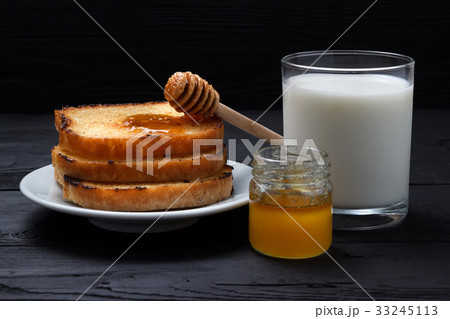 Toasts on a white plate, a glass of milk  33245113