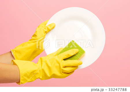Hands in yellow protective gloves washing a plate 33247788