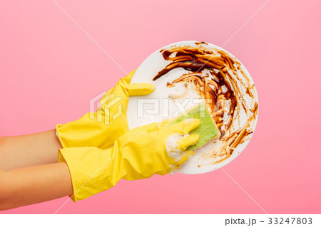 Hands in yellow protective gloves washing a plate 33247803