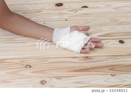 hand gauze bandage wrapping his injury On wooden 33248031