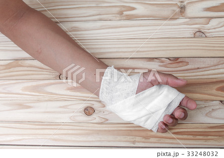 hand gauze bandage wrapping his injury On wooden 33248032