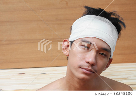 Young man with trauma of head by Medical bandage Young man with trauma of head by Medical bandage 33248100
