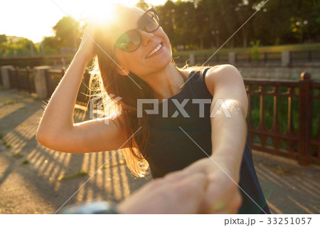 Follow me - happy young woman pulling guy's hand - hand in hand Follow me - happy young woman pulling guy's hand - hand in hand 33251057