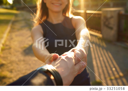 Follow me - happy young woman pulling guy's hand - hand in hand Follow me - happy young woman pulling guy's hand - hand in hand 33251058