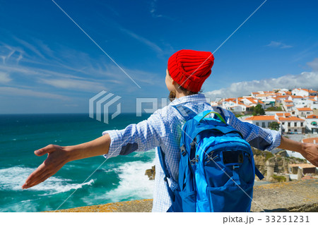 Woman with a backpack is spinning her arms out 33251231