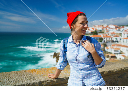 Woman enjoys a view of the ocean coast Woman enjoys a view of the ocean coast 33251237