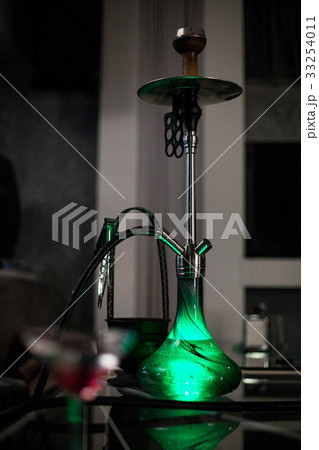 The green hookah is standing on the table. The green hookah is standing on the table. 33254011
