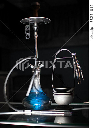 Blue hookah placed on the table. 33254012