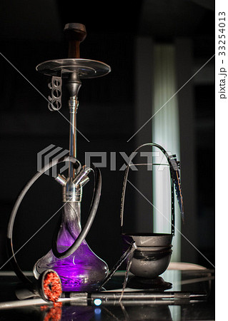 The purple hookah is placed on a table. 33254013