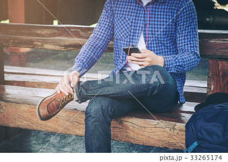 Travel man using mobile phone at train station Travel man using mobile phone at train station 33265174