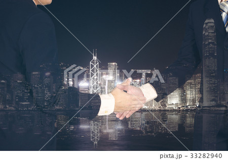 Double exposure of businessman shaking hand 33282940