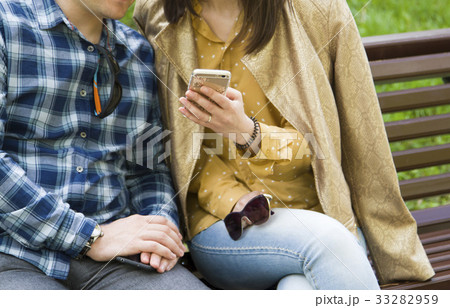 A girl shows a guy something in a phone 33282959