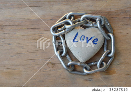 chain roll heart stone on wooden board 33287316