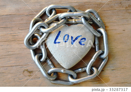 chain roll heart stone on wooden board 33287317