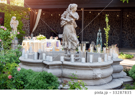 Fountain decorated with statues and candles 33287835