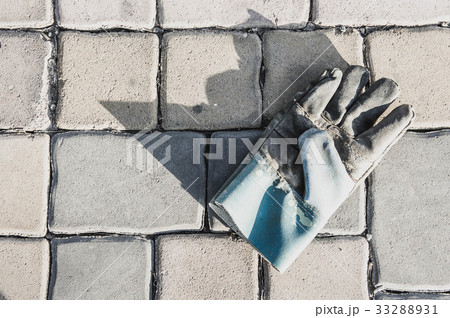 Old leather gloves leave on paving footpath 33288931