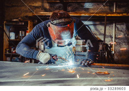 Man with safety glasses welding 33289603