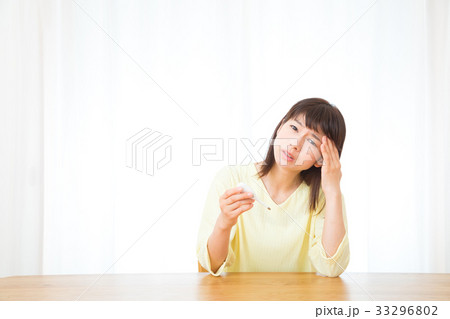 体温計を持つ女性　頭痛　頭が痛い　ネガティブイメージ　女性　ポートレート　20代　30代 33296802